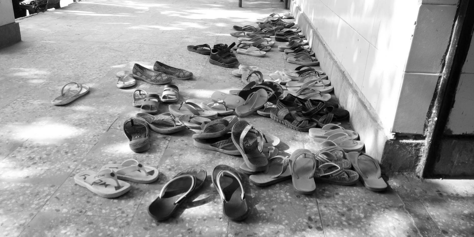A pile of chappals outside a classroom